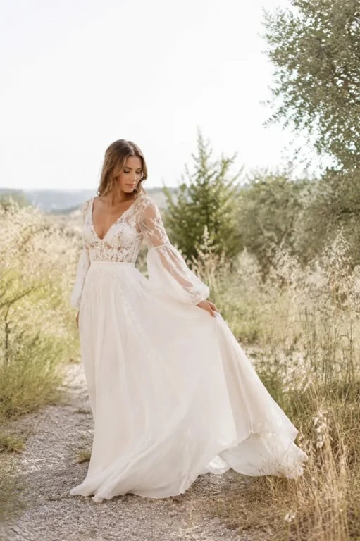 Robe de mariée boheme fluide en dentelle dans un jardin champêtre